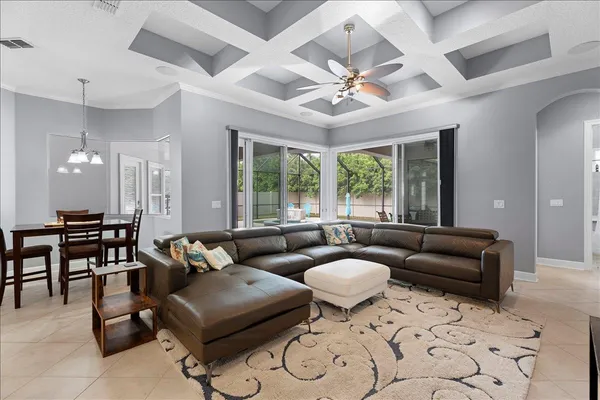 a living room with furniture kitchen view and a chandelier