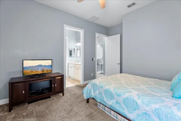 an empty room with chandelier fan and windows