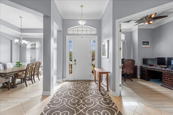 a view of a hallway with dining area and chandelier