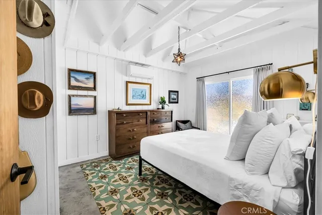 a bedroom with a bed and dresser with mirror