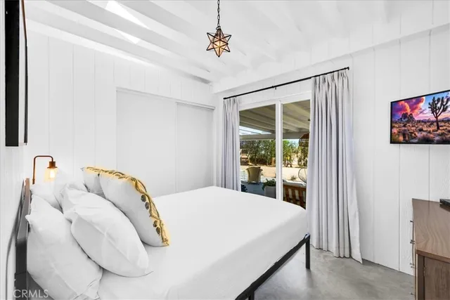 a bedroom with a bed and a flat screen tv