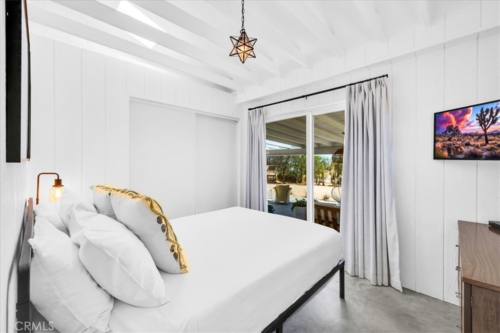 2837 Border Avenue Joshua Tree, CA 92252 - Photo 17 of 52 a bedroom with a bed and a flat screen tv