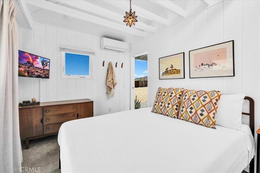 2837 Border Avenue Joshua Tree, CA 92252 - Photo 18 of 52 a bedroom with a large bed and a chandelier