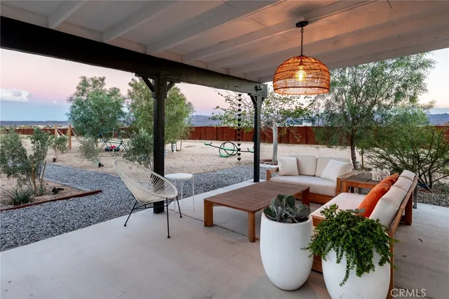 a living room with patio furniture and a floor to ceiling window