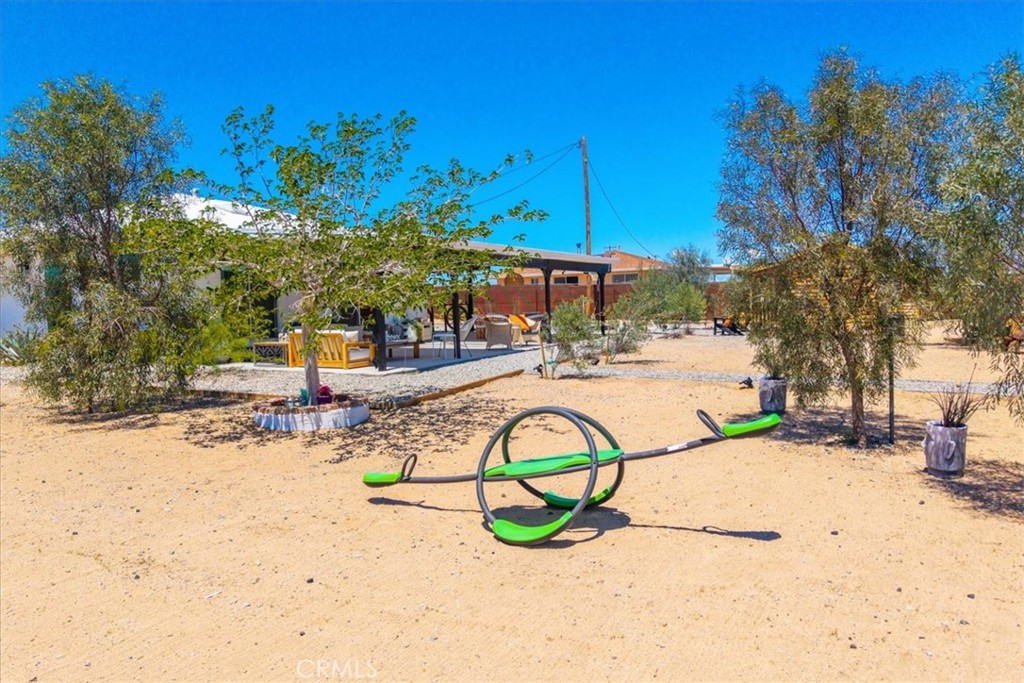 2837 Border Avenue Joshua Tree, CA 92252 - Photo 47 of 52 a view of swimming pool with a table and chairs under an umbrella
