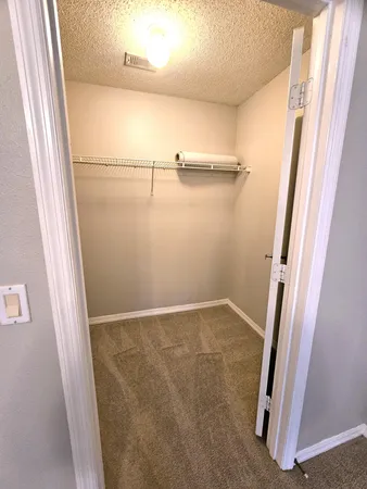 a view of walk in closet with empty racks