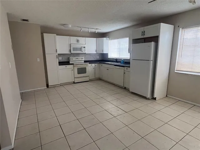 a kitchen with stainless steel appliances a refrigerator sink and cabinets