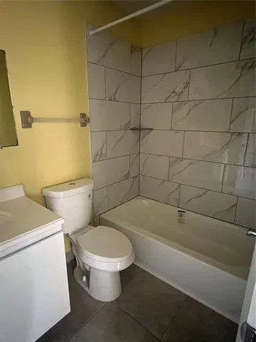 a white toilet and tub sitting next to a bathroom sink