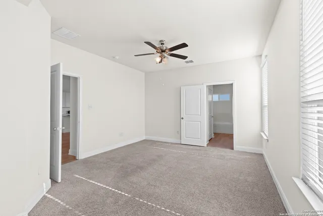 a view of a livingroom with a ceiling fan & window