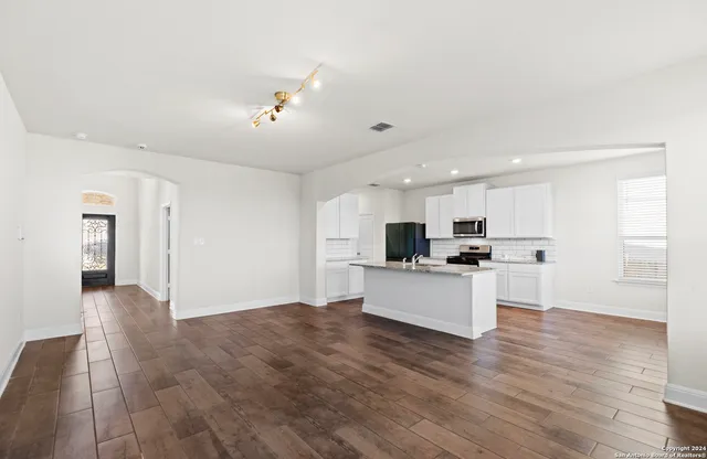 a view of kitchen with kitchen island stainless steel appliances refrigerator stove microwave and cabinets