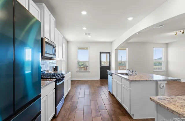 a kitchen with stainless steel appliances a sink stove and cabinets