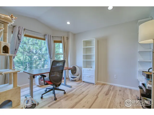 a view of a workspace with furniture and a window