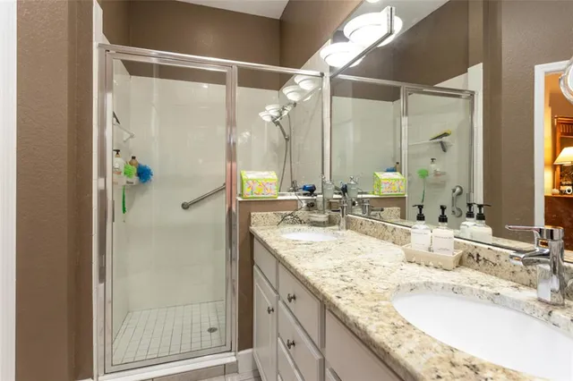 a bathroom with a granite countertop shower sink and mirror