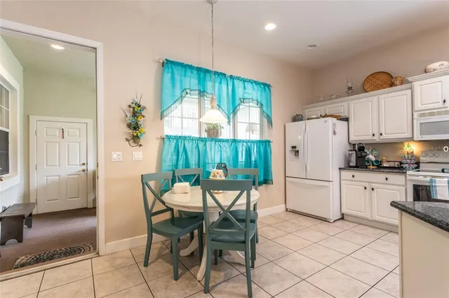 a kitchen with a table chairs refrigerator and cabinets