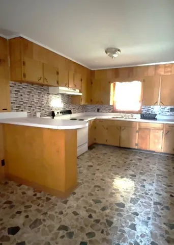 a kitchen with stainless steel appliances granite countertop a sink stove and cabinets
