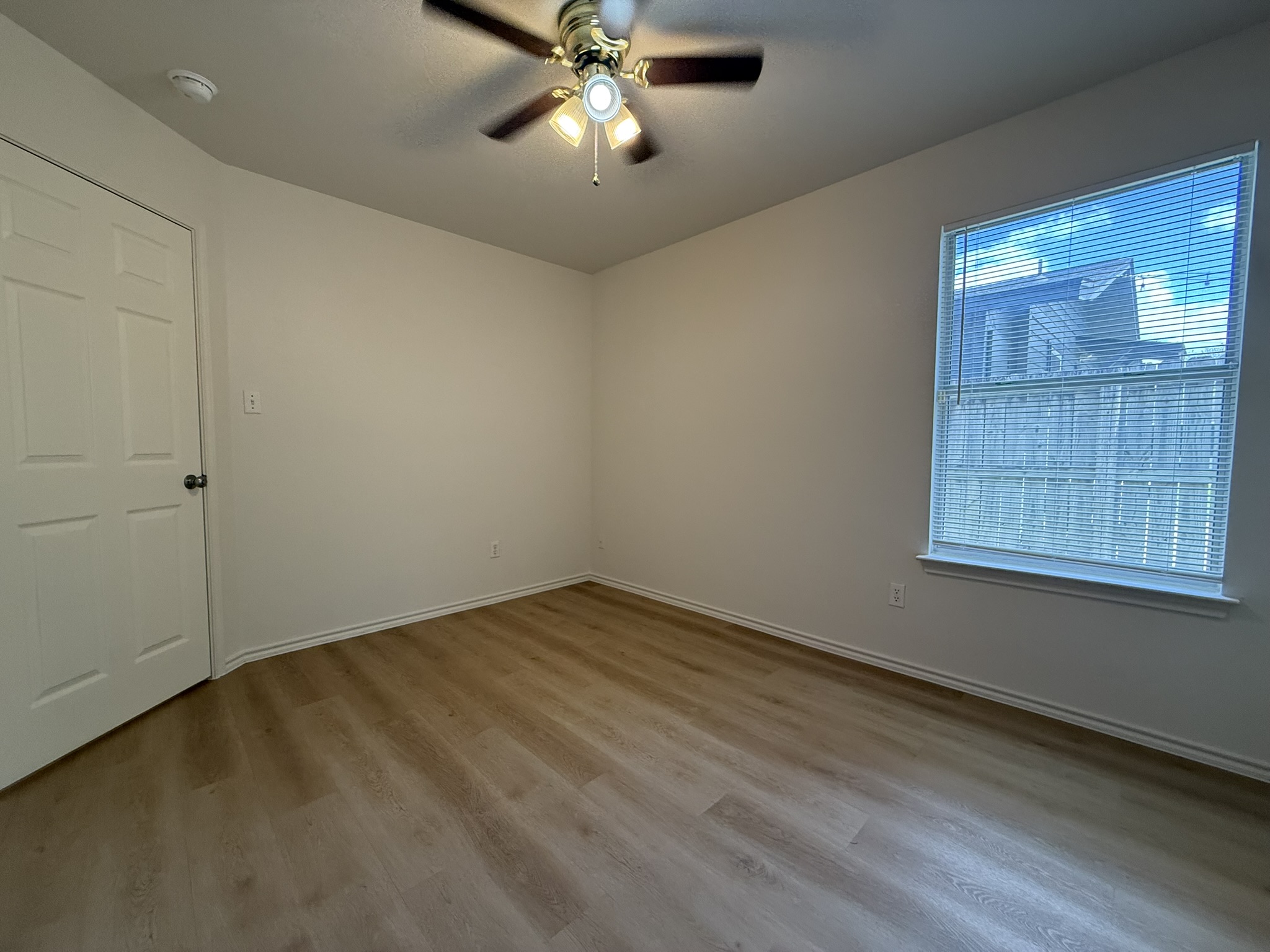 1209 Armadillo Road, Unit A Austin, TX 78745 - Photo 11 of 15 Empty room with ceiling fan and light wood finished floors