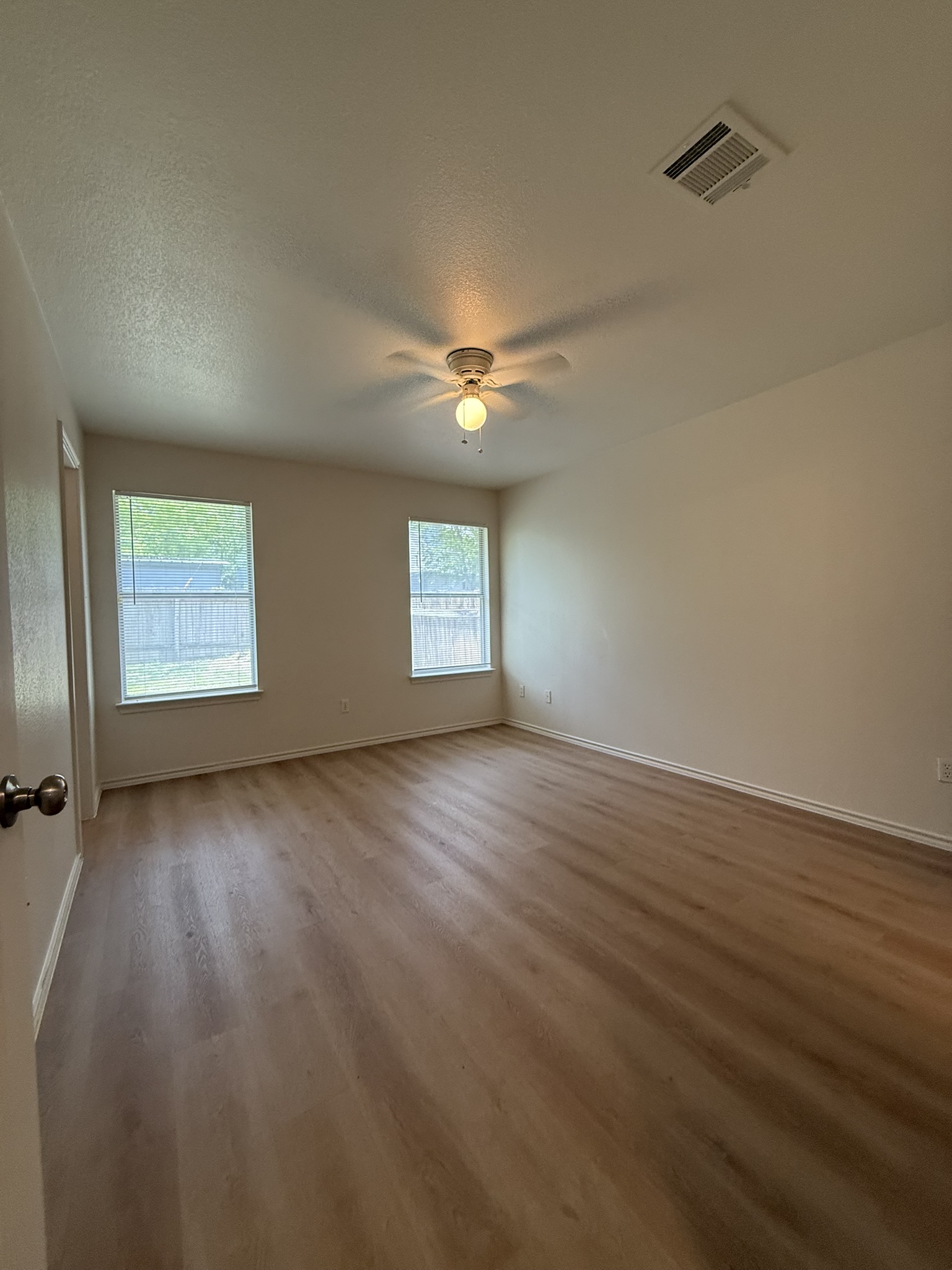 1209 Armadillo Road, Unit A Austin, TX 78745 - Photo 12 of 15 Unfurnished room with ceiling fan, wood finished floors, and a textured ceiling