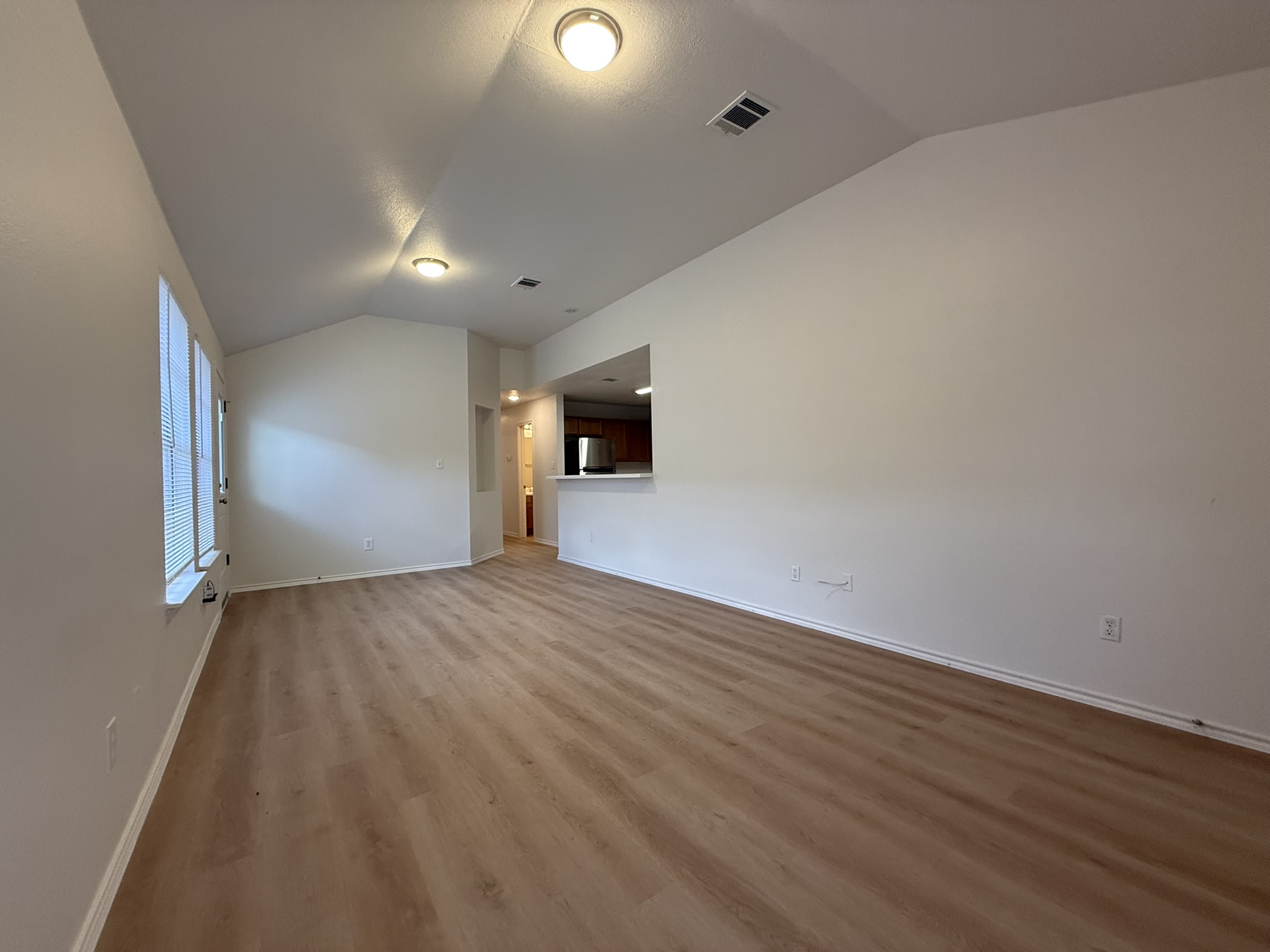 1209 Armadillo Road, Unit A Austin, TX 78745 - Photo 5 of 15 Unfurnished living room with baseboards and light wood-style flooring