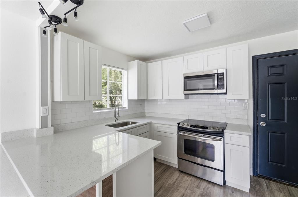 1615 Northeast 9th Street Ocala, FL 34470 - Photo 16 of 24 a kitchen with a sink stove and microwave