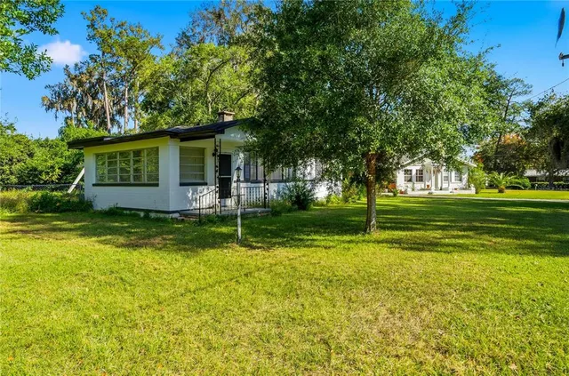 a view of a house with a big yard and potted plants