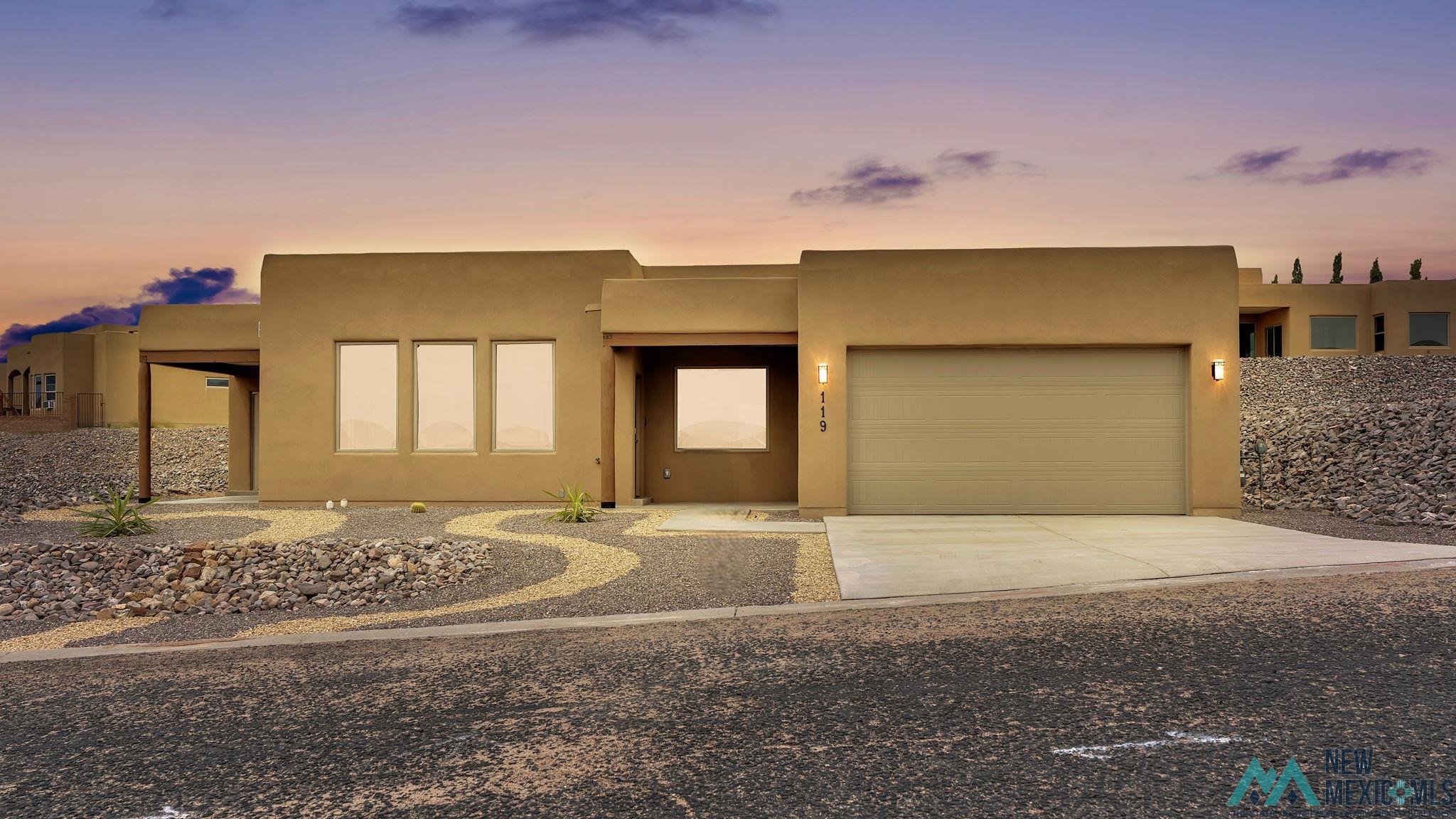 119 Mesa Grande Road Elephant Butte, NM 87935 - Photo 34 of 34 Southwest-style home featuring stucco siding, concrete driveway, and an attached garage
