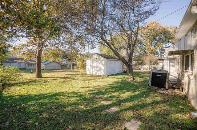 a backyard of a house with table and chairs