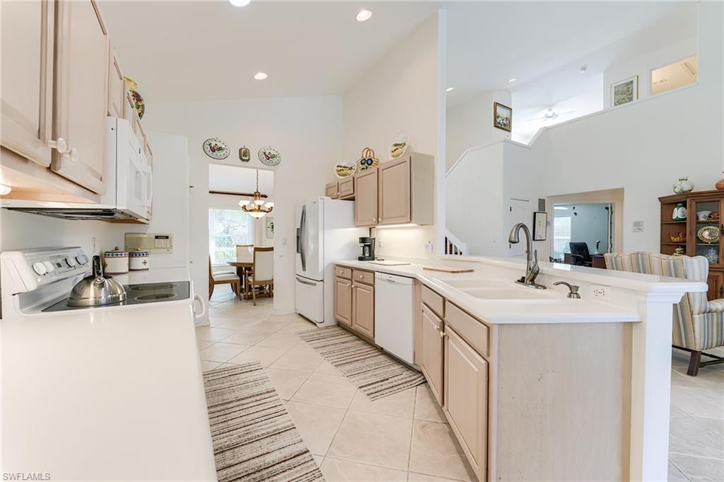 9156 Spring Run Boulevard Estero, FL 34135 - Photo 8 of 34 a kitchen with a sink a stove and cabinets