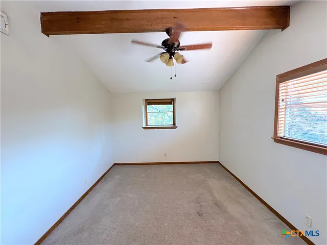 an empty room with a window and a ceiling fan