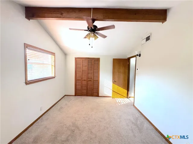 a view of a livingroom with a chandelier fan and windows