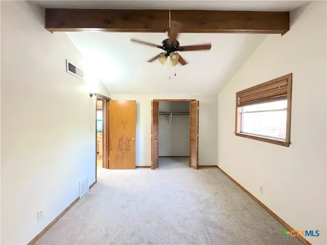 a view of a livingroom with a ceiling fan and window