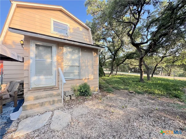 a backyard of a house with plants and tree