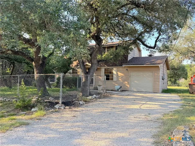 a view of a house with backyard and tree