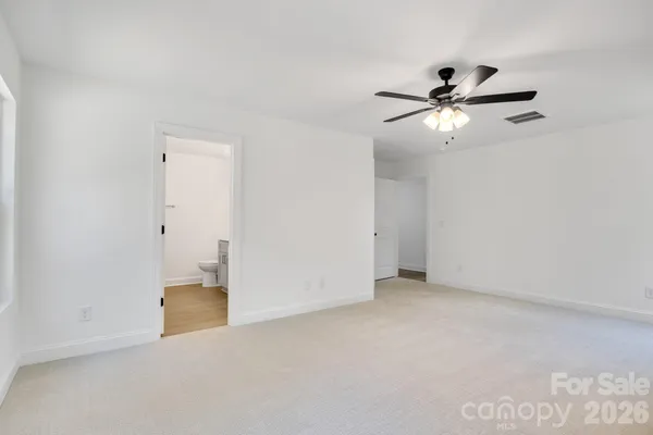 an empty room with a ceiling fan and a window