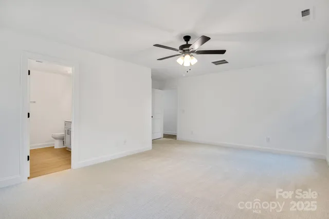 an empty room with a ceiling fan and a window