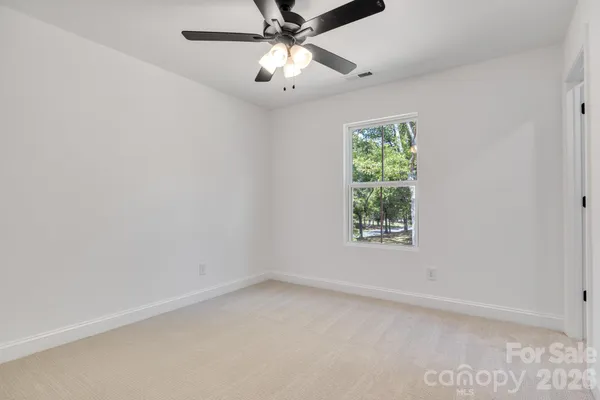 an empty room with a window and a fan