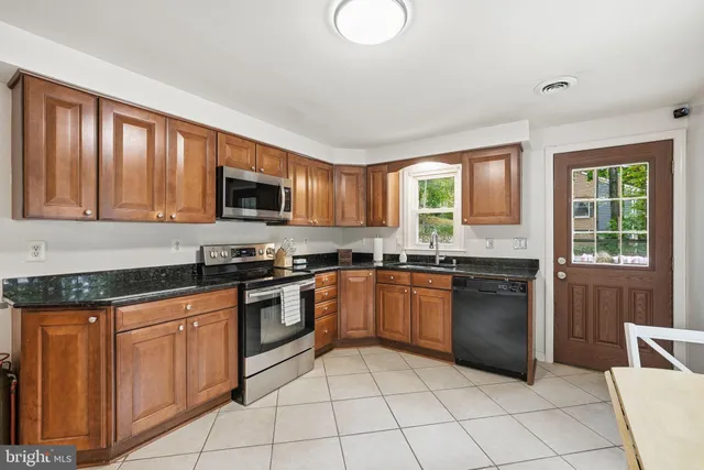 a kitchen with a sink a counter top space and stainless steel appliances
