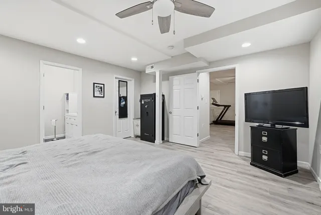 a large bedroom with a bed and a flat tv screen on dresser