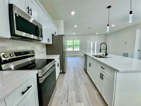 a view of a kitchen with center island and stainless steel appliances