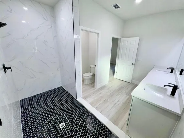 a bathroom with a sink a toilet and shower