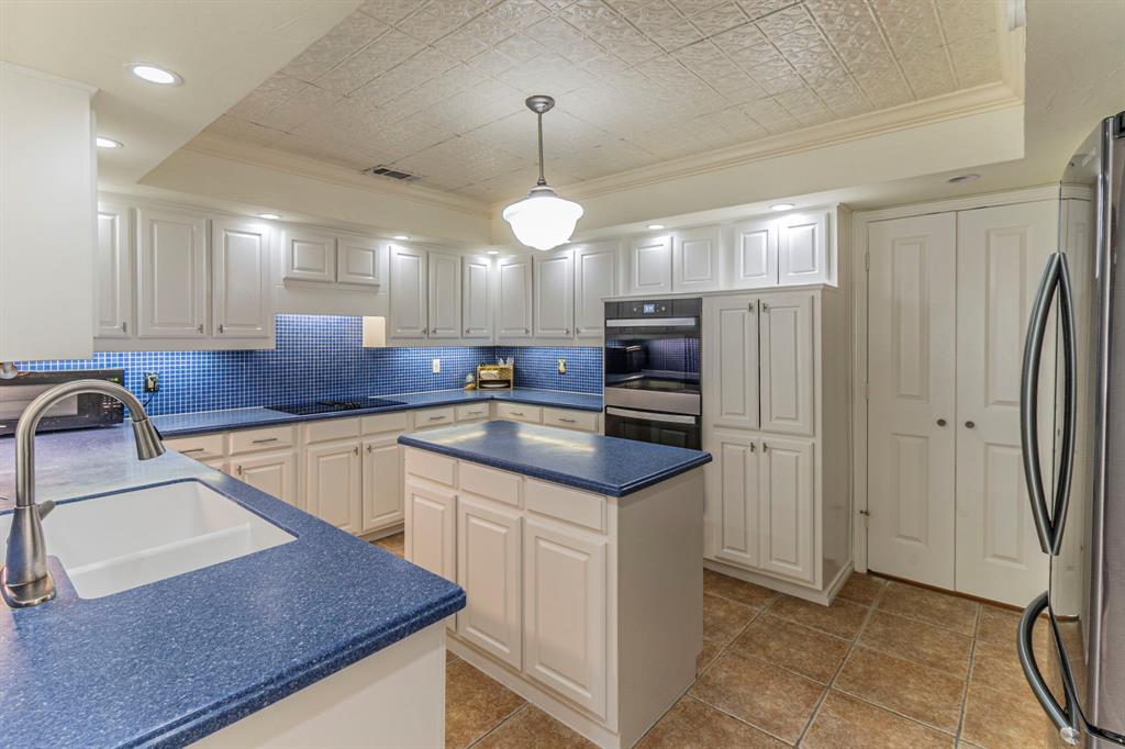 127 Nicklaus Nook Lancaster, TX 75146 - Photo 10 of 37 Kitchen featuring ornamental molding, an ornate ceiling, dark countertops, freestanding refrigerator, and a raised ceiling