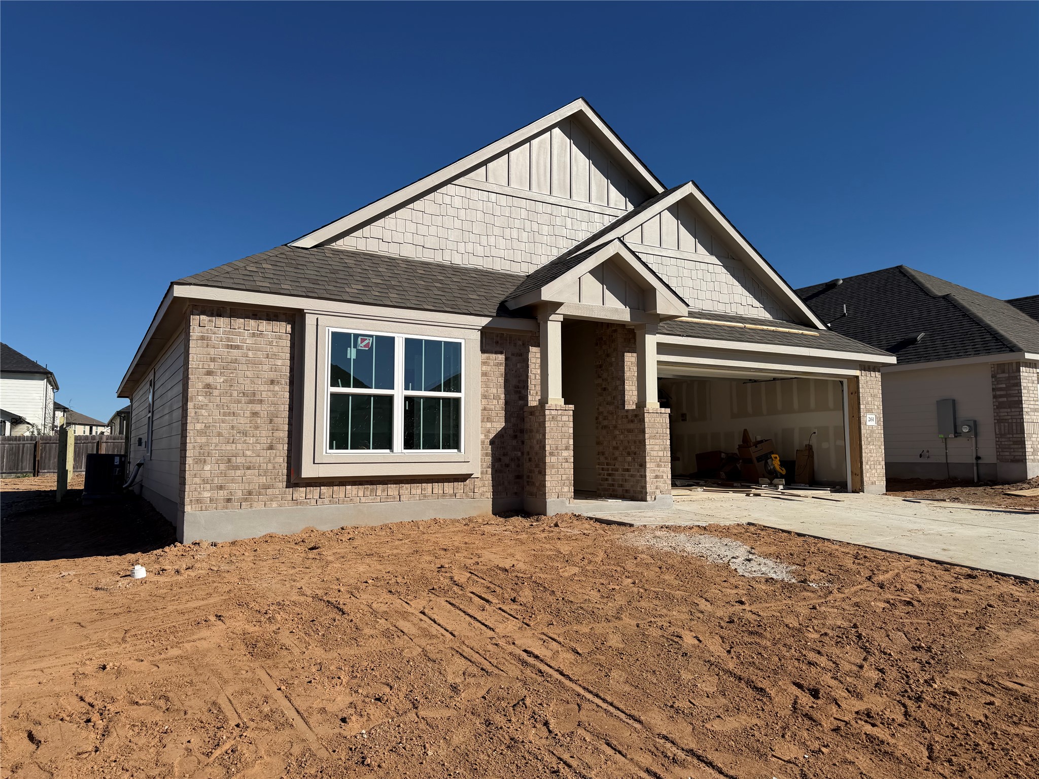 Craftsman inspired home with driveway, a garage, brick siding, board and batten siding, and a shingled roof