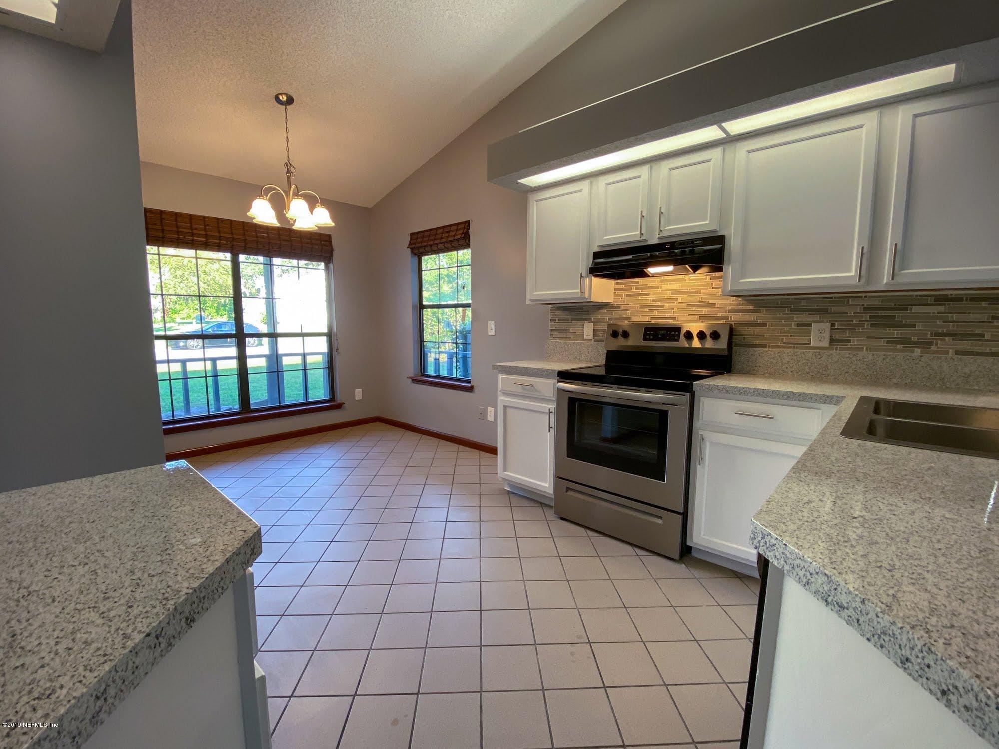 2148 Rothbury Drive Jacksonville, FL 32221 - Photo 12 of 36 a kitchen with stainless steel appliances granite countertop a stove a sink and a microwave