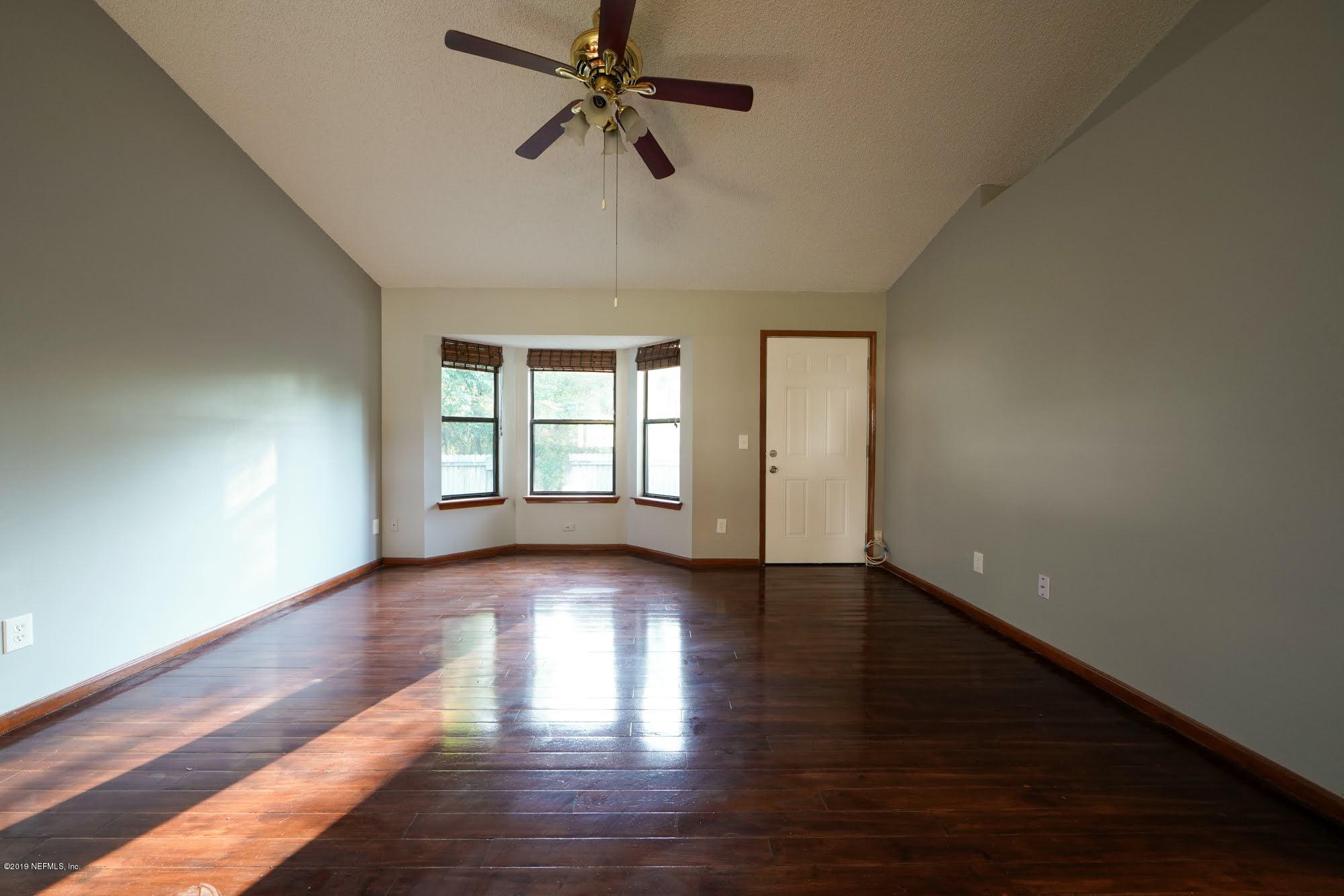2148 Rothbury Drive Jacksonville, FL 32221 - Photo 14 of 36 a view of an empty room with a window and wooden floor