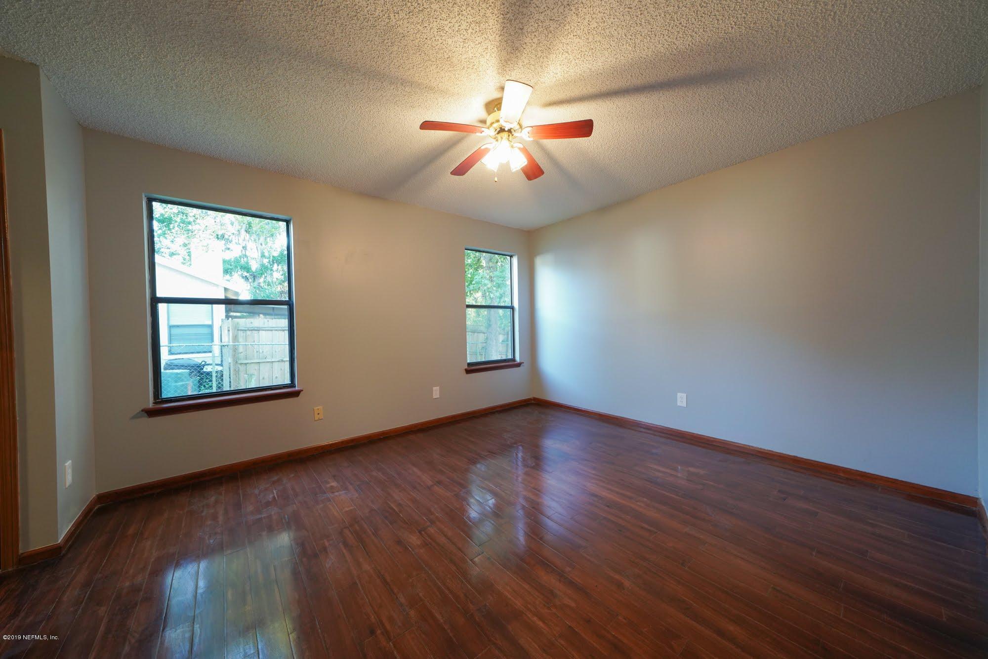 2148 Rothbury Drive Jacksonville, FL 32221 - Photo 15 of 36 a view of an empty room with wooden floor and a window