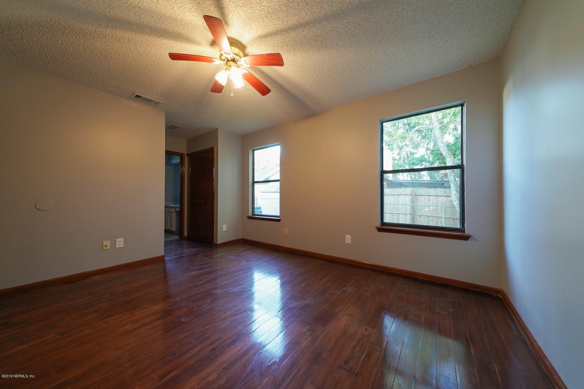 2148 Rothbury Drive Jacksonville, FL 32221 - Photo 18 of 36 a view of an empty room with wooden floor and a window