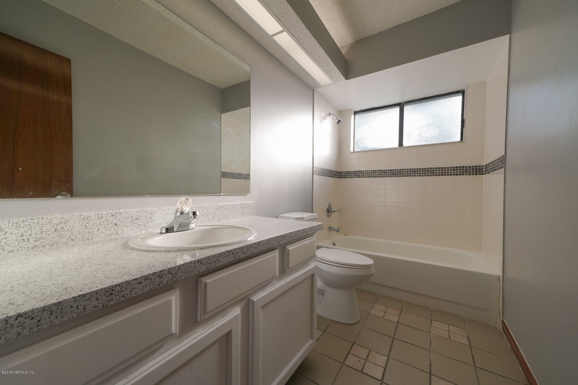 2148 Rothbury Drive Jacksonville, FL 32221 - Photo 20 of 36 a bathroom with a granite countertop toilet a sink and a mirror
