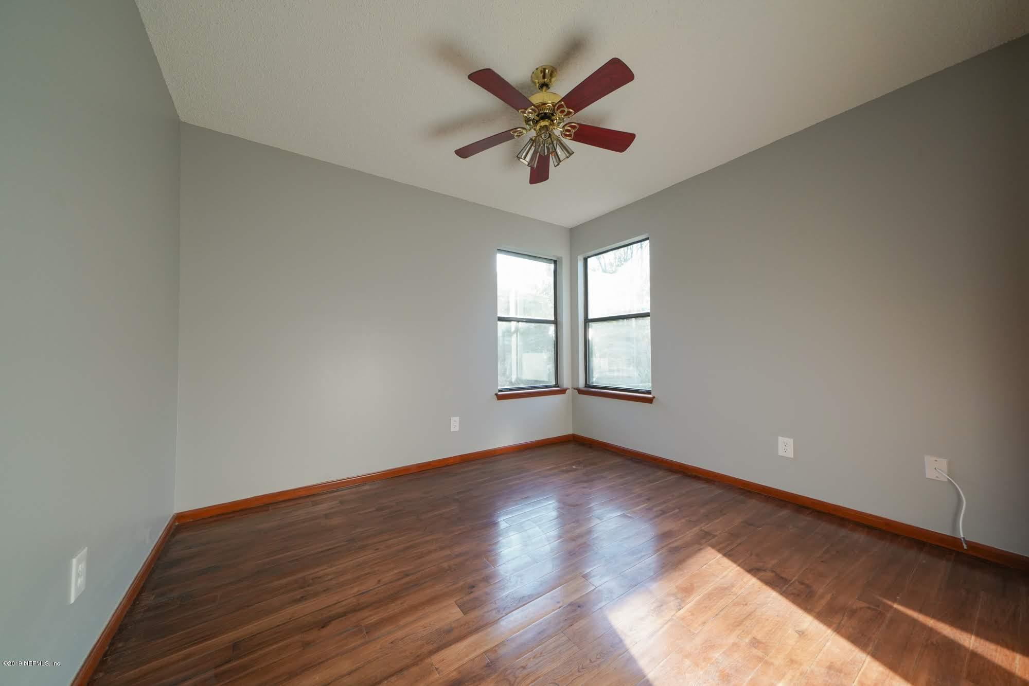 2148 Rothbury Drive Jacksonville, FL 32221 - Photo 21 of 36 an empty room with wooden floor and ceiling fan