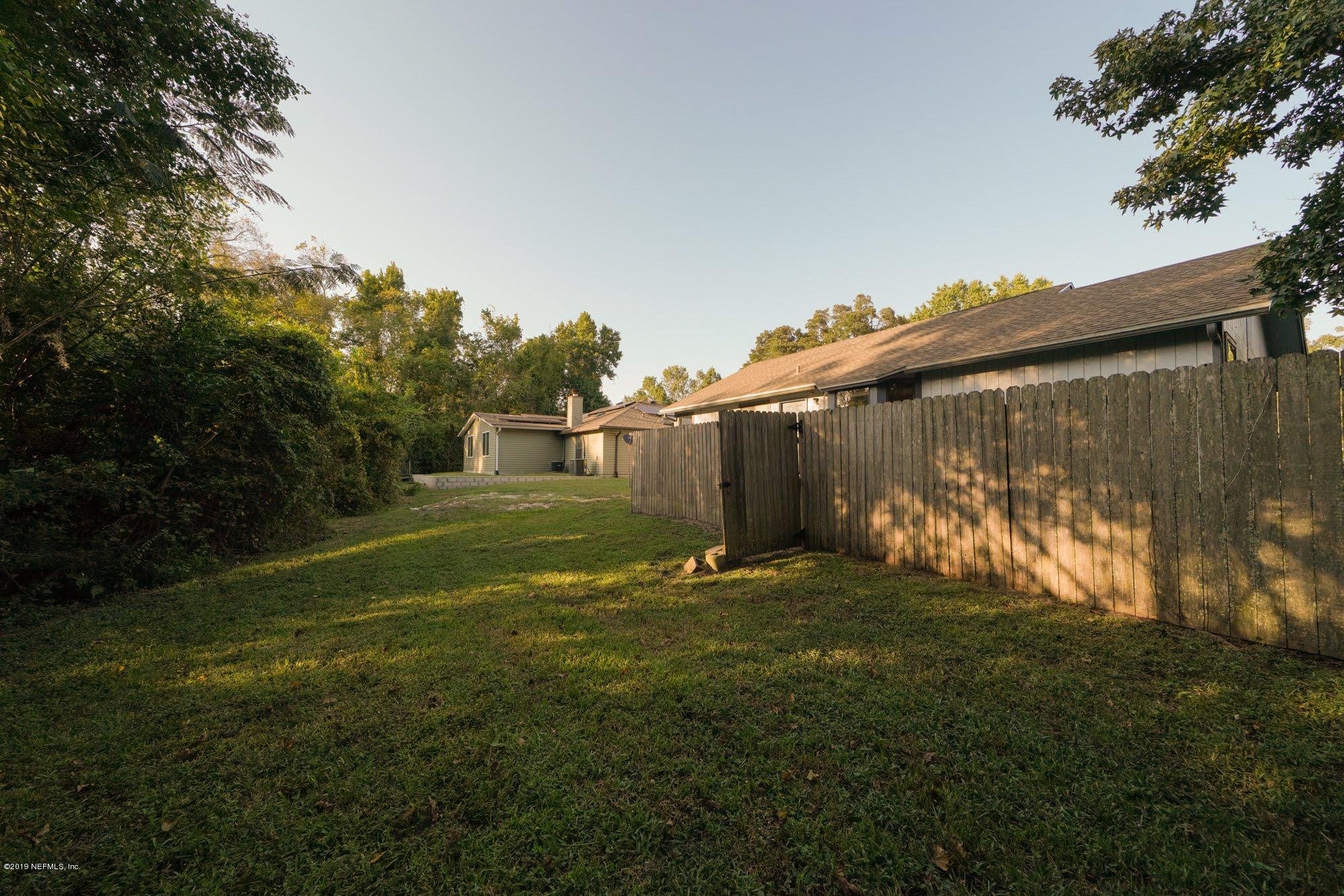 2148 Rothbury Drive Jacksonville, FL 32221 - Photo 28 of 36 a backyard of a house with plants and large trees