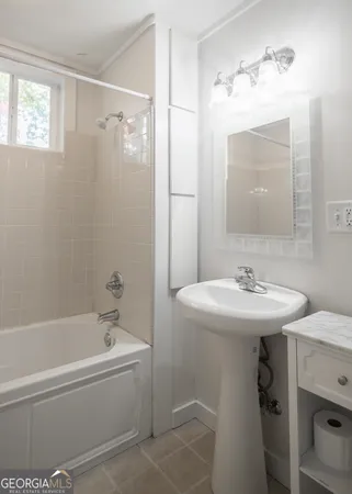 a bathroom with a sink a mirror a bathtub and shower