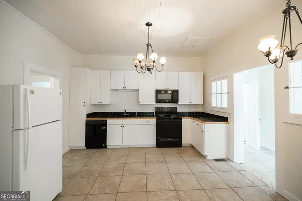 a kitchen with kitchen island granite countertop a refrigerator oven a sink and dishwasher